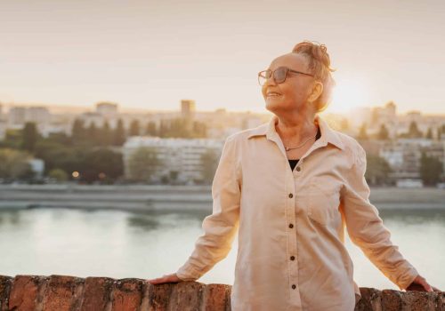Portrait of a happy attractive mature senior woman 60 years old at sunset